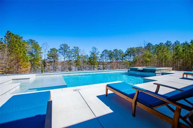 view of pool with a patio and a pool with connected hot tub