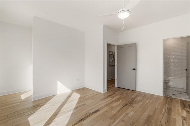 interior space with ensuite bathroom, ceiling fan, and light wood-type flooring