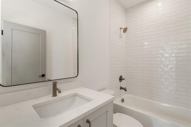 full bathroom featuring tiled shower / bath, vanity, and toilet