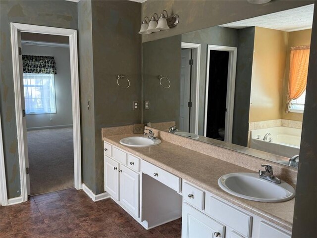 bathroom with vanity, a tub to relax in, and toilet