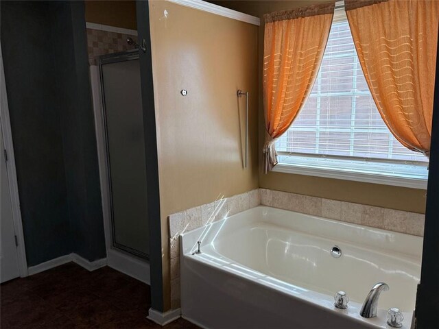 bathroom featuring ornamental molding and shower with separate bathtub