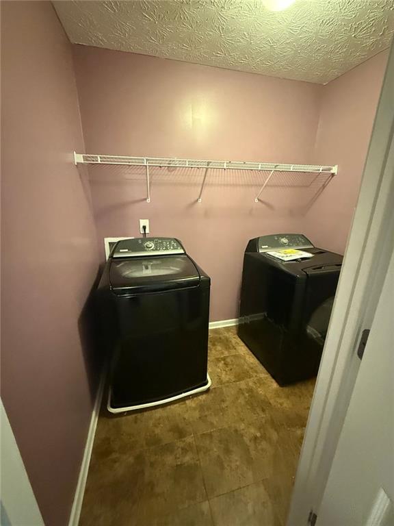 laundry room featuring a textured ceiling and separate washer and dryer