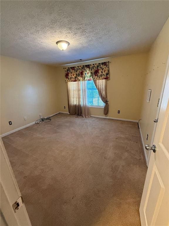 carpeted empty room featuring a textured ceiling