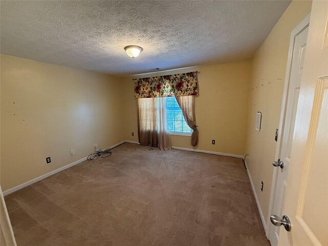 carpeted empty room with a textured ceiling