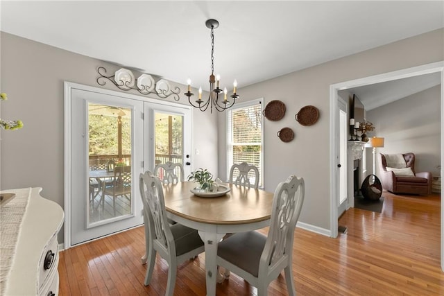 dining room featuring baseboards, a notable chandelier, and light wood finished floors