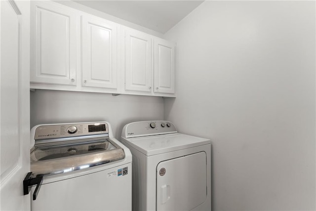 laundry area with separate washer and dryer and cabinet space
