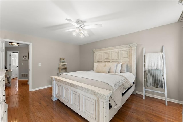 bedroom featuring baseboards, ceiling fan, visible vents, and hardwood / wood-style flooring