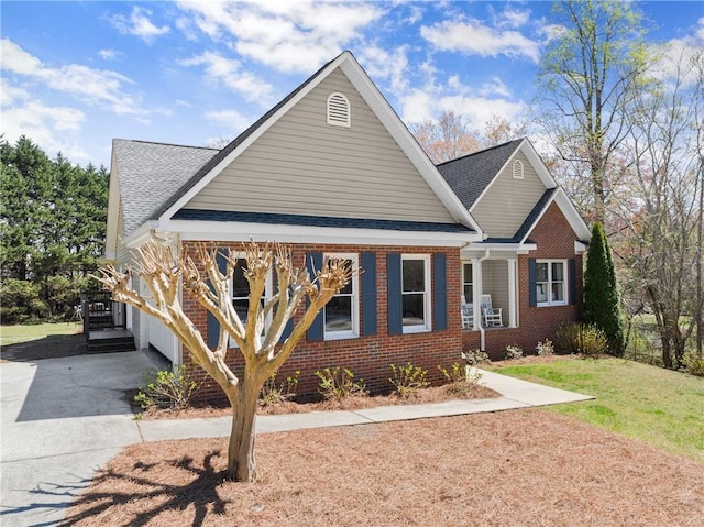 view of front facade with brick siding, a front yard, and roof with shingles