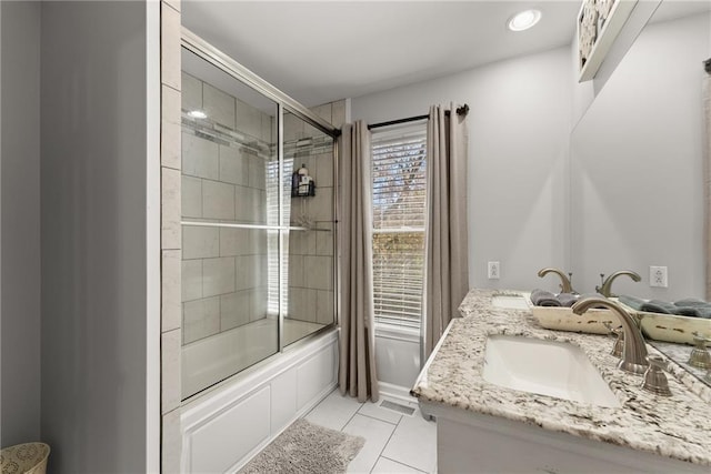 full bathroom featuring tile patterned floors, a sink, combined bath / shower with glass door, and double vanity