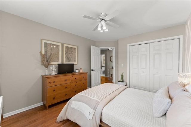 bedroom featuring a ceiling fan, a closet, baseboards, and wood finished floors