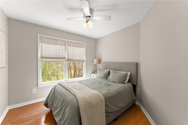 bedroom with baseboards, wood finished floors, and a ceiling fan