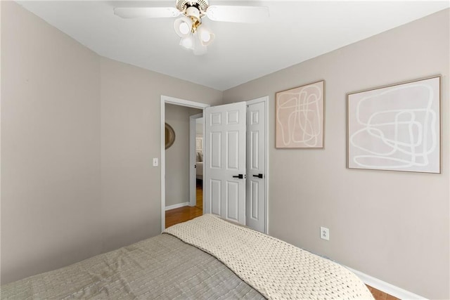 bedroom with a closet, baseboards, and ceiling fan