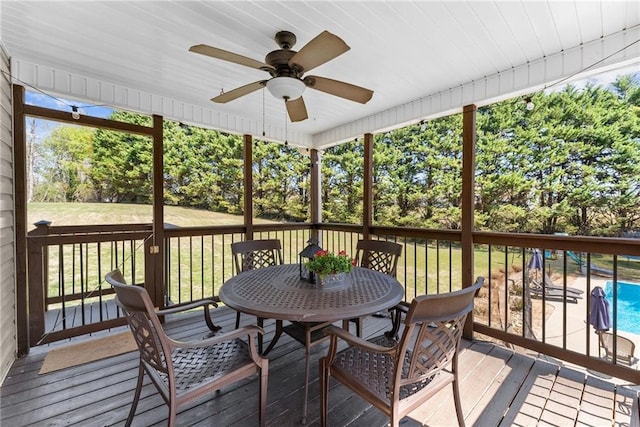 sunroom featuring a ceiling fan and outdoor dining space