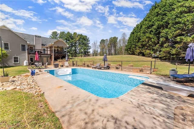 view of swimming pool featuring a lawn, fence, and a patio area