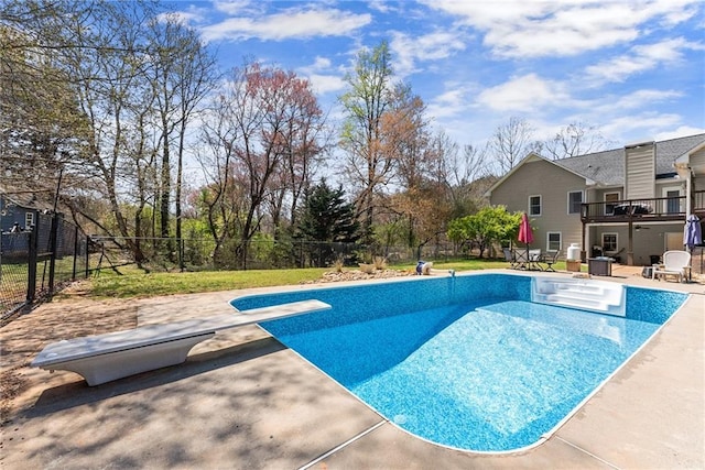 view of swimming pool with a patio, a fenced in pool, a fenced backyard, and a diving board