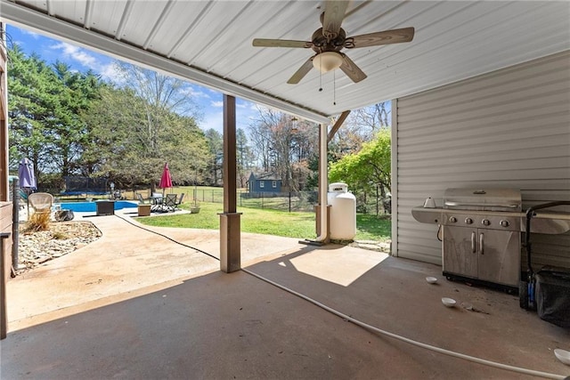 view of patio with fence, area for grilling, and ceiling fan
