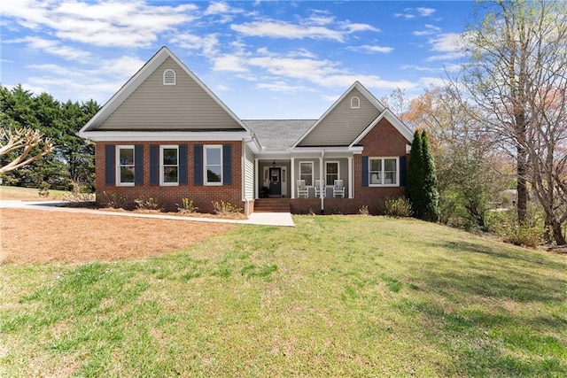 view of front of house featuring brick siding, a front lawn, and a porch