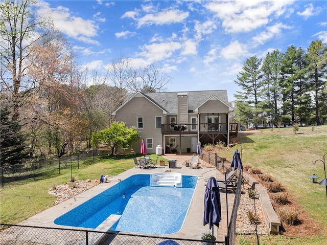 view of pool with a fenced backyard, a lawn, a wooden deck, and a patio area