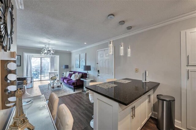 2657 Lenox Rd Unit C30, Atlanta, GA 30324 - kitchen with a peninsula, white cabinets, open floor plan, hanging light fixtures, and dark stone counters