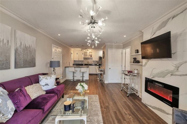2657 Lenox Rd Unit C30, Atlanta, GA 30324 - living area featuring dark wood-type flooring, a glass covered fireplace, ornamental molding, a textured ceiling, and a chandelier