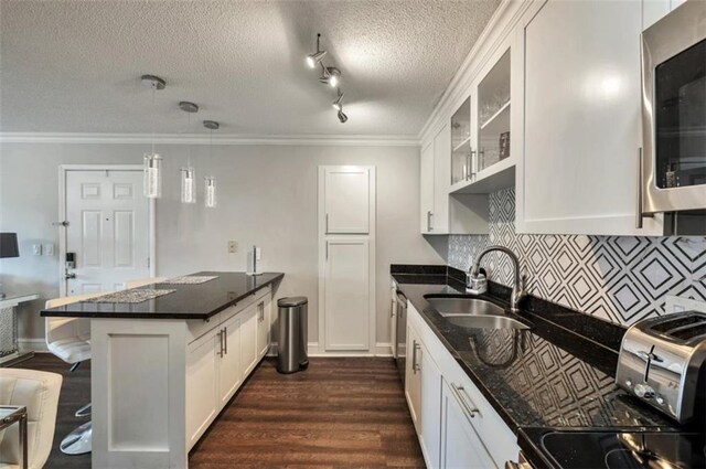 2657 Lenox Rd Unit C30, Atlanta, GA 30324 - kitchen featuring pendant lighting, stainless steel appliances, glass insert cabinets, white cabinets, and a sink