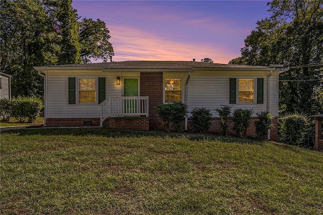 ranch-style home with a yard