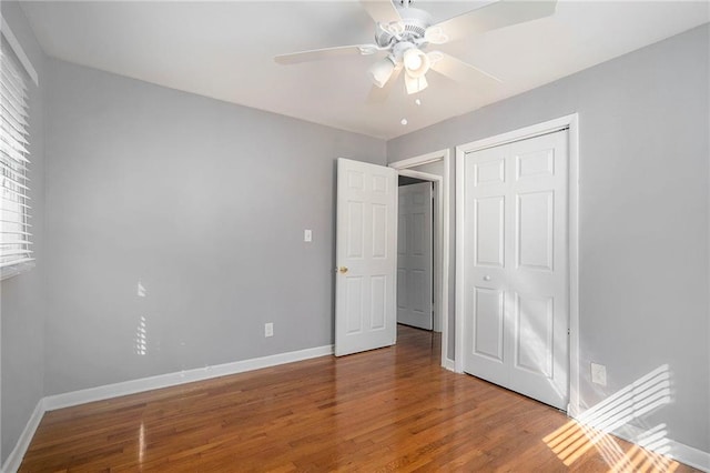 unfurnished bedroom featuring a closet, hardwood / wood-style flooring, and ceiling fan