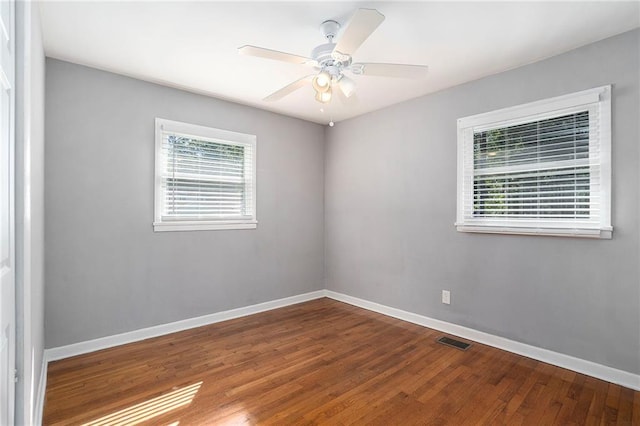 empty room with hardwood / wood-style floors, ceiling fan, and a wealth of natural light