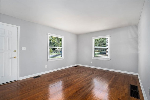 unfurnished room with dark wood-type flooring and a healthy amount of sunlight