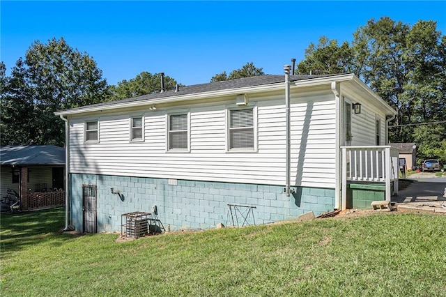 view of side of property featuring a lawn and cooling unit