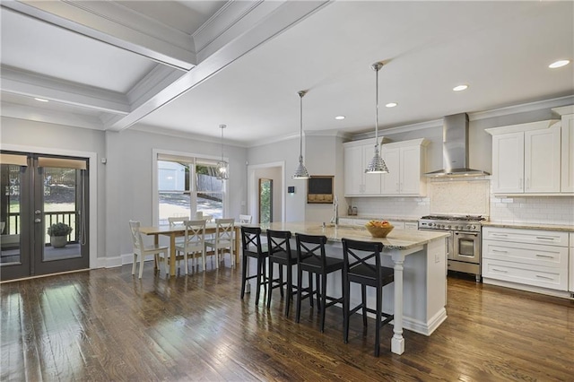 1297 Conway Rd, Decatur, GA 30030 - kitchen with wall chimney exhaust hood, double oven range, a sink, a kitchen island with sink, and a breakfast bar