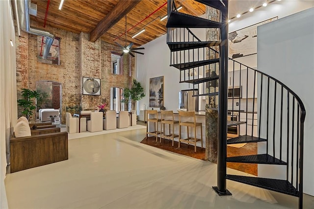 170 Boulevard Se 115E, Atlanta, GA 30312 - staircase with a towering ceiling, wood ceiling, beamed ceiling, ceiling fan, and brick wall