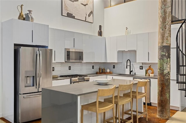 170 Boulevard Se 115E, Atlanta, GA 30312 - kitchen with stainless steel appliances, a sink, backsplash, a kitchen bar, and a kitchen island