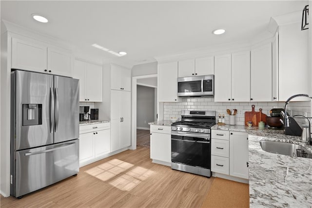 kitchen featuring light hardwood / wood-style flooring, sink, stainless steel appliances, and white cabinetry