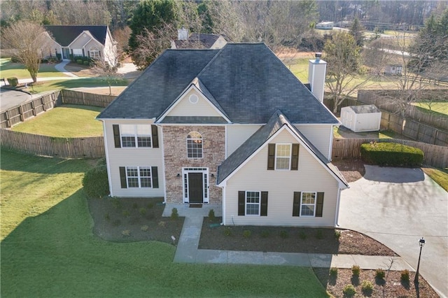 view of front of property with a front lawn and a storage unit