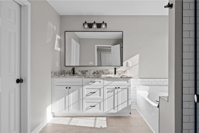 bathroom featuring a washtub, tile patterned floors, and vanity