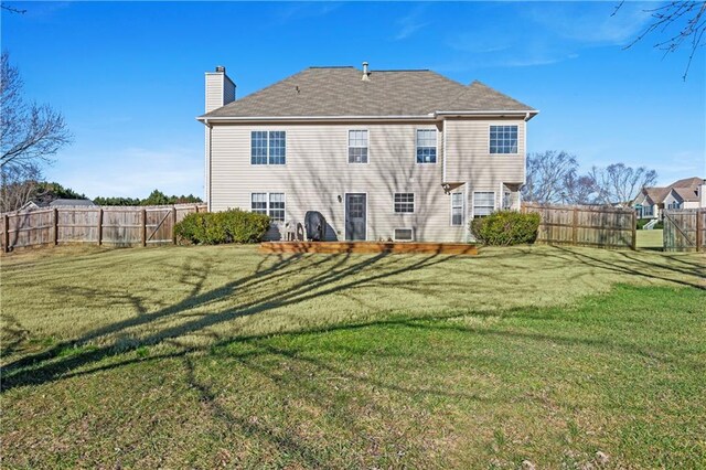 rear view of house featuring a lawn