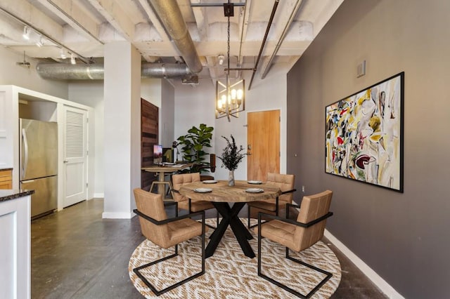 dining area featuring track lighting and an inviting chandelier