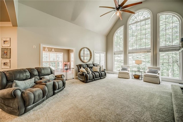 living room with high vaulted ceiling, ceiling fan, a wealth of natural light, and carpet