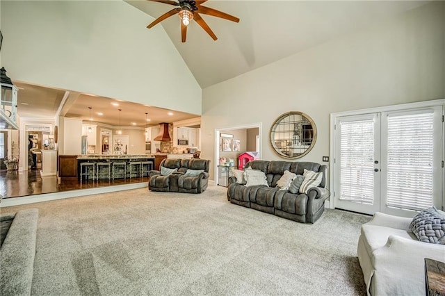 living room featuring ceiling fan, carpet flooring, and high vaulted ceiling