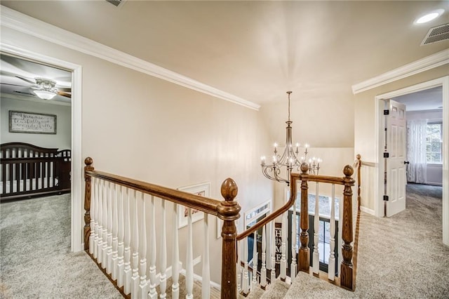 corridor featuring a chandelier, crown molding, and light colored carpet