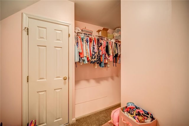 walk in closet featuring dark carpet