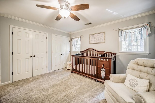 bedroom with light carpet, a nursery area, and multiple windows