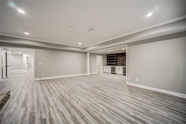 unfurnished living room featuring beverage cooler and light wood-type flooring