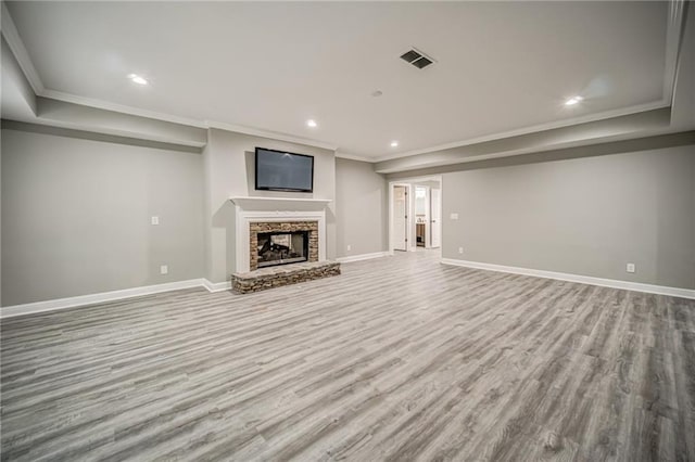 unfurnished living room featuring crown molding, light wood-type flooring, and a fireplace