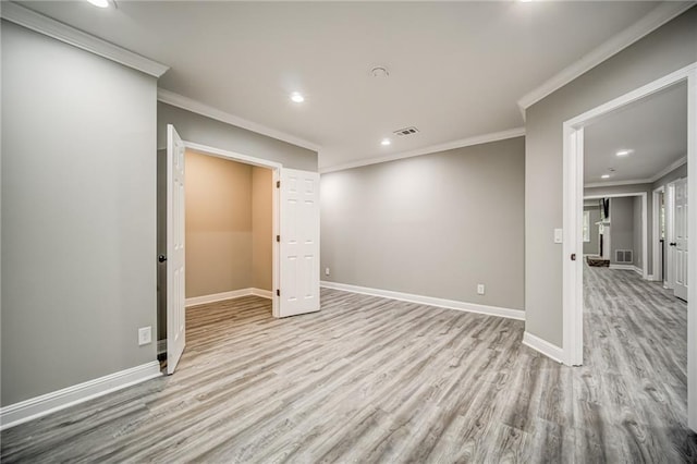 spare room with ornamental molding and light wood-type flooring