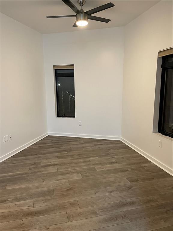 unfurnished room featuring ceiling fan, baseboards, and wood finished floors