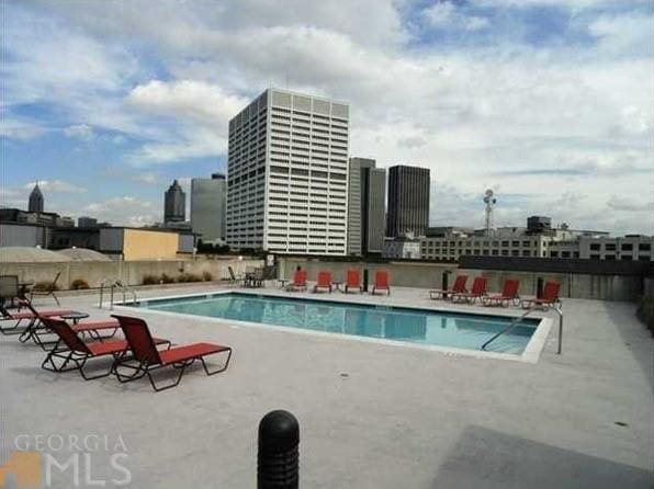 pool featuring a view of city and a patio