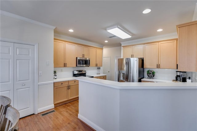 kitchen with visible vents, light wood-style floors, appliances with stainless steel finishes, and light brown cabinetry