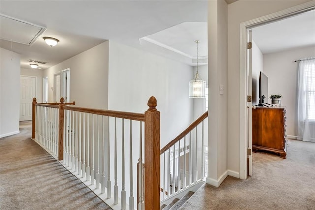 hallway with an upstairs landing, visible vents, attic access, and carpet